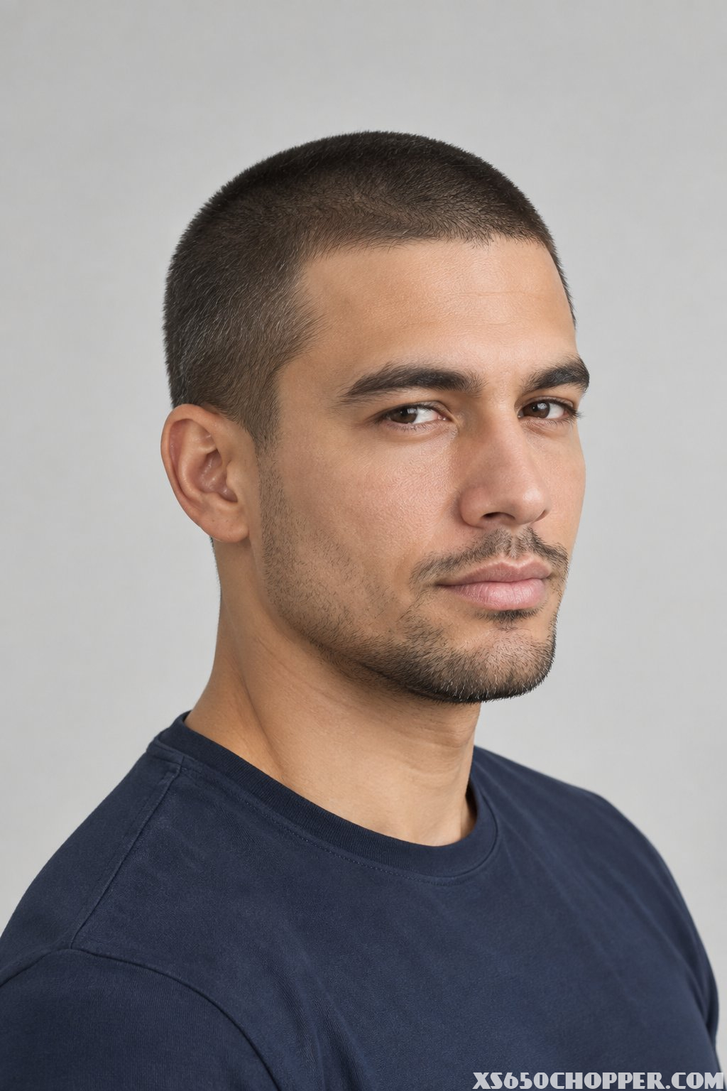 Man with a short, evenly clipped Number 2 haircut shown in a three-quarter portrait.