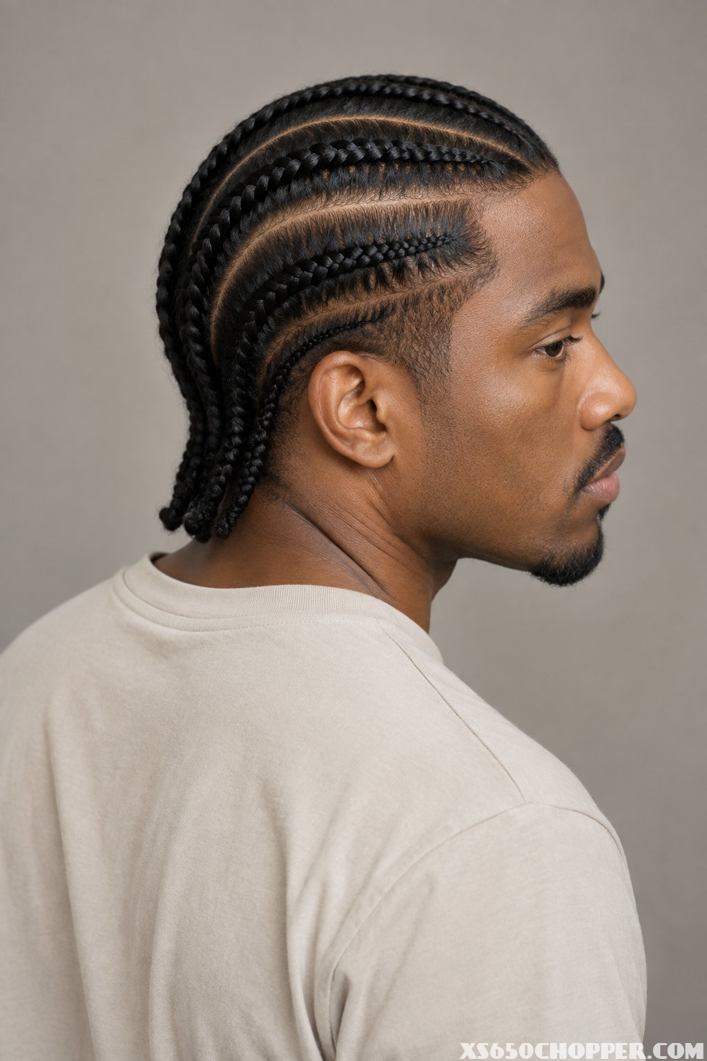 A man with two layers of straight-back cornrow braids viewed from behind.