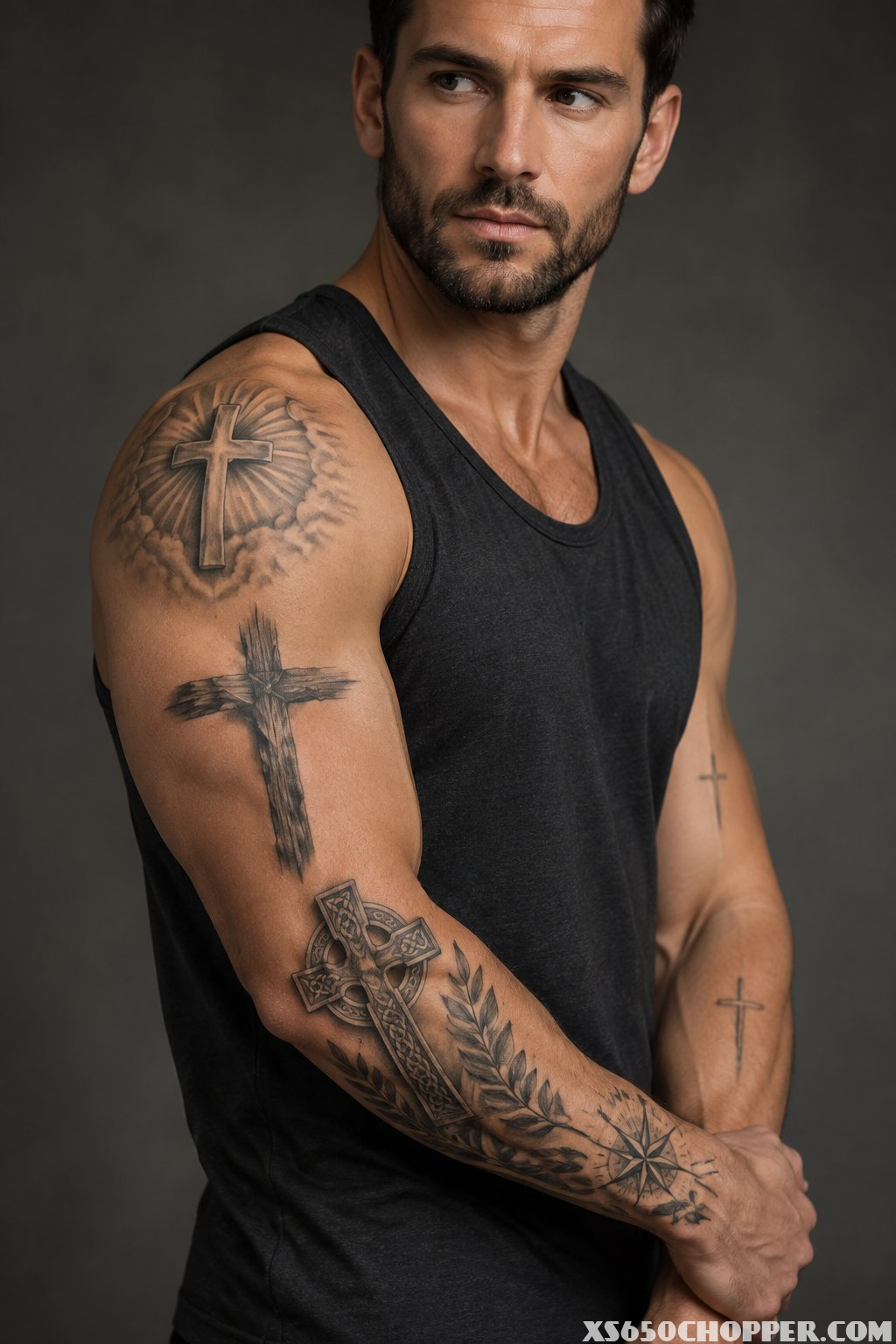 A confident man displays several detailed cross tattoos on his arms and shoulder.