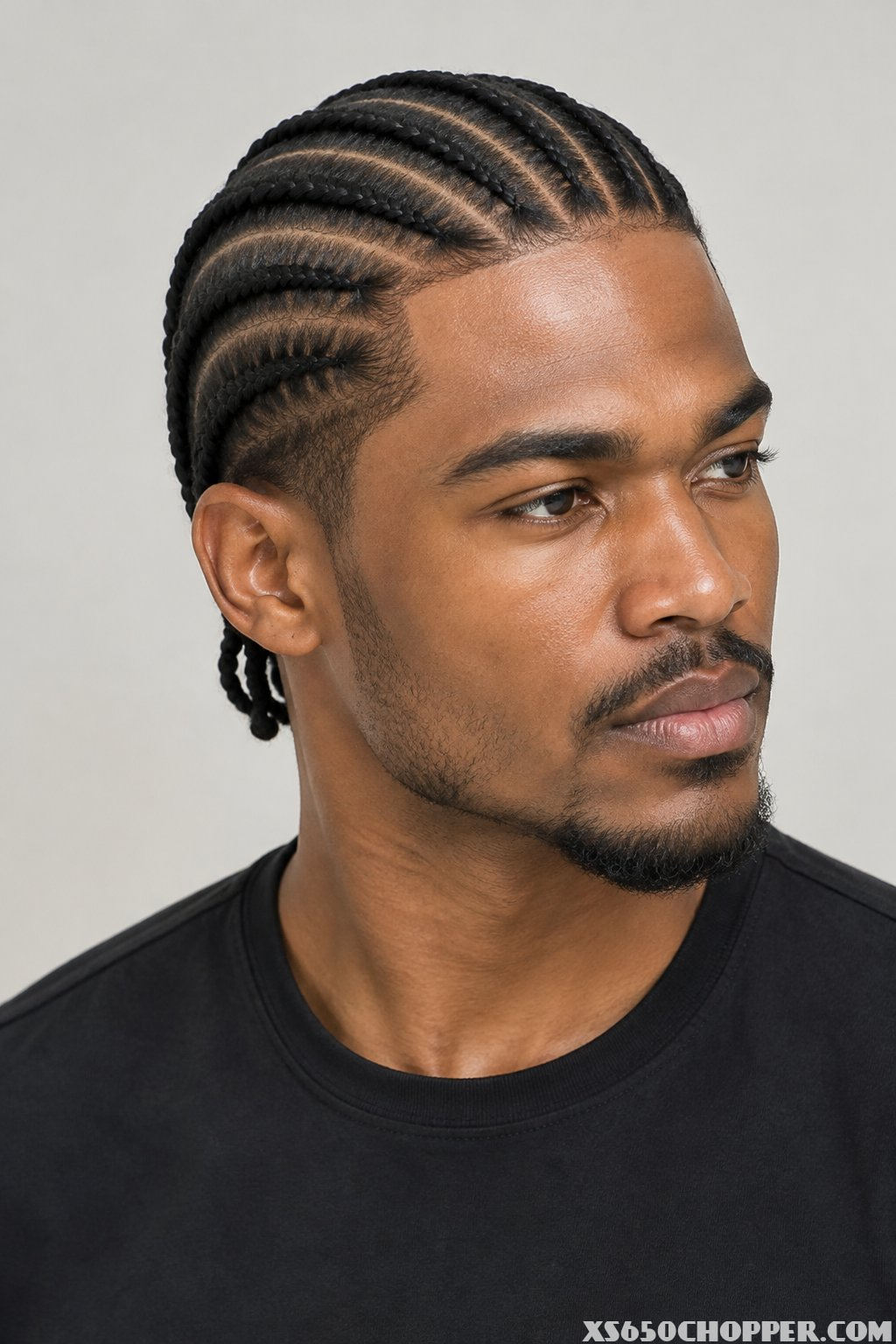 A man poses for a portrait against a light background.