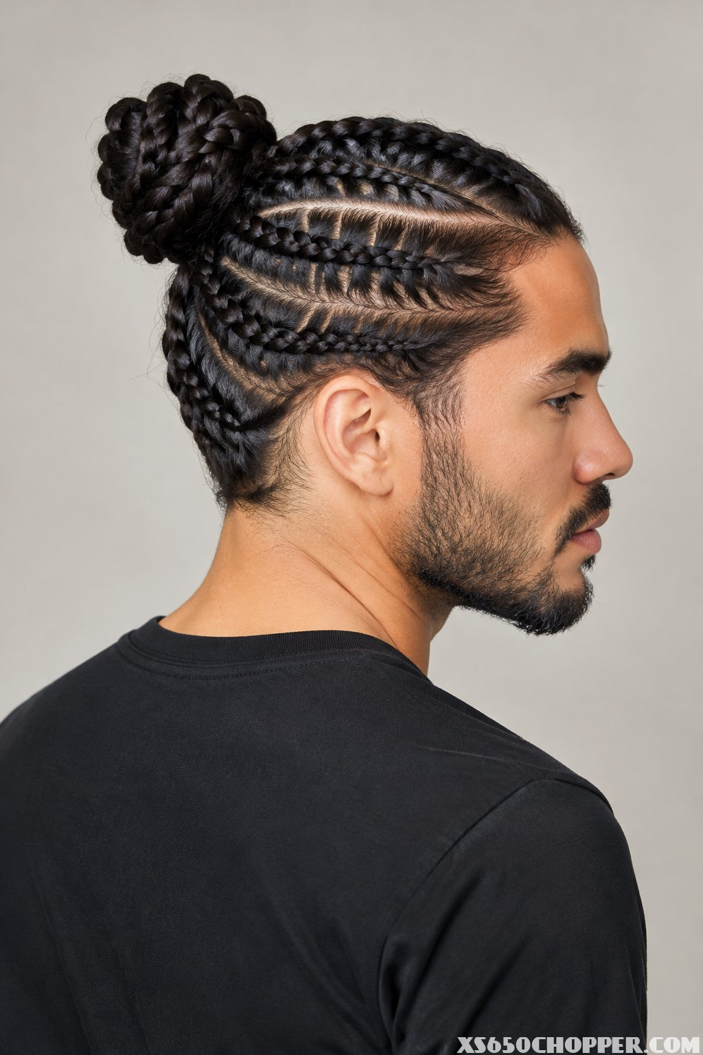 A man with braided hair gathered into a bun.