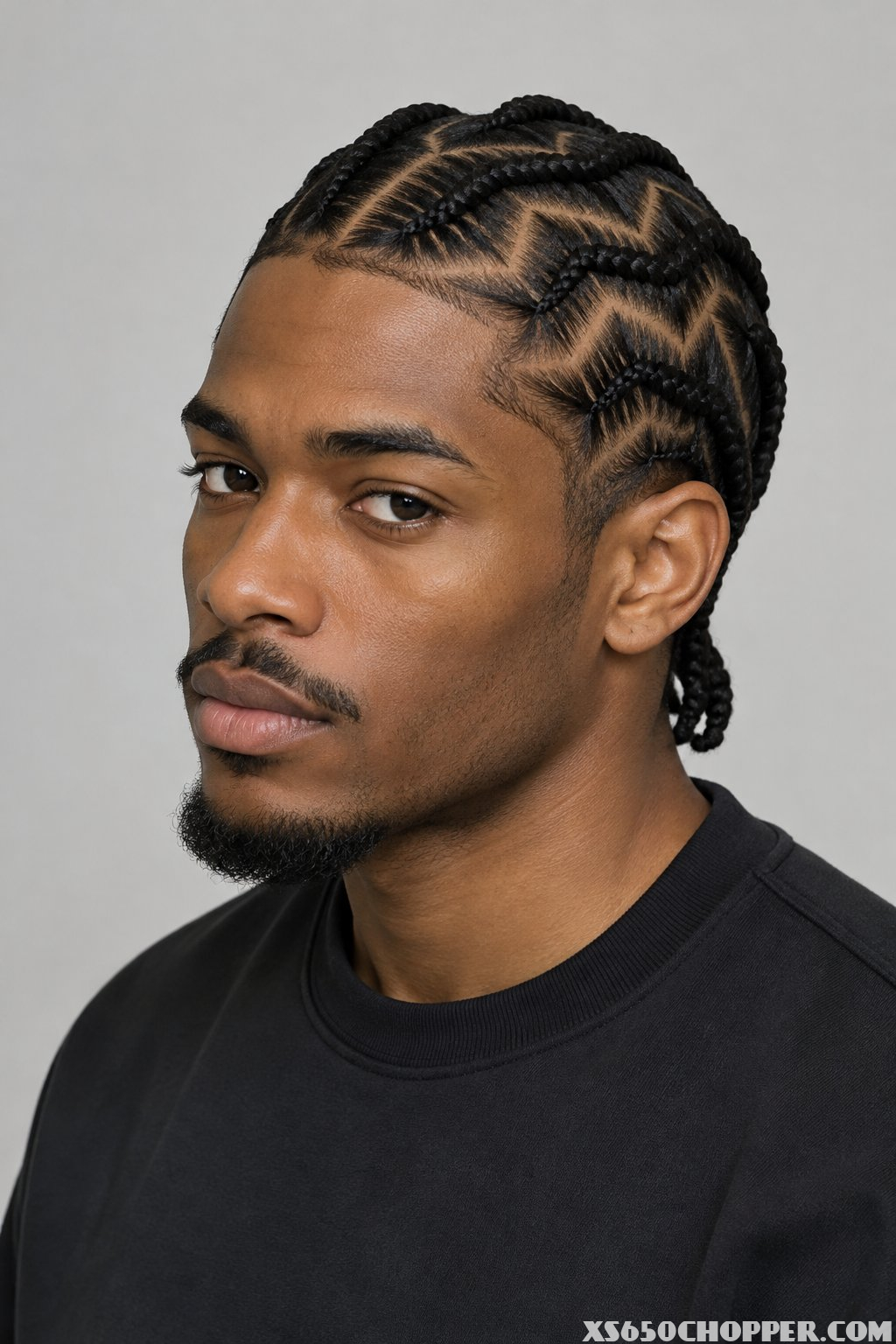A man poses for a portrait against a plain background.