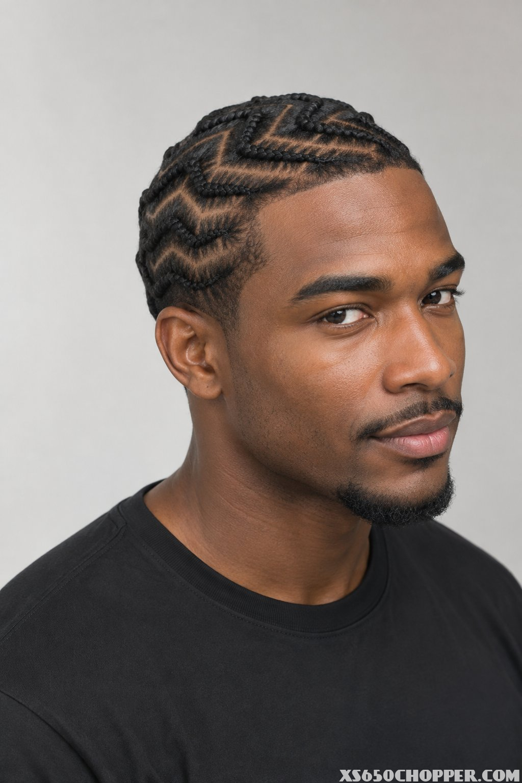 A man poses for a portrait against a plain background.