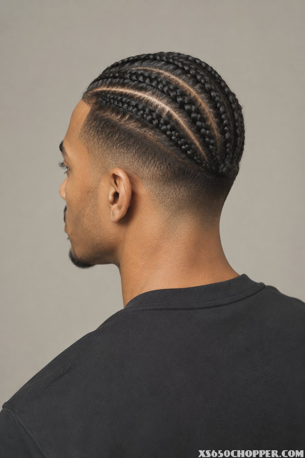 A man shown from behind with braided hair.