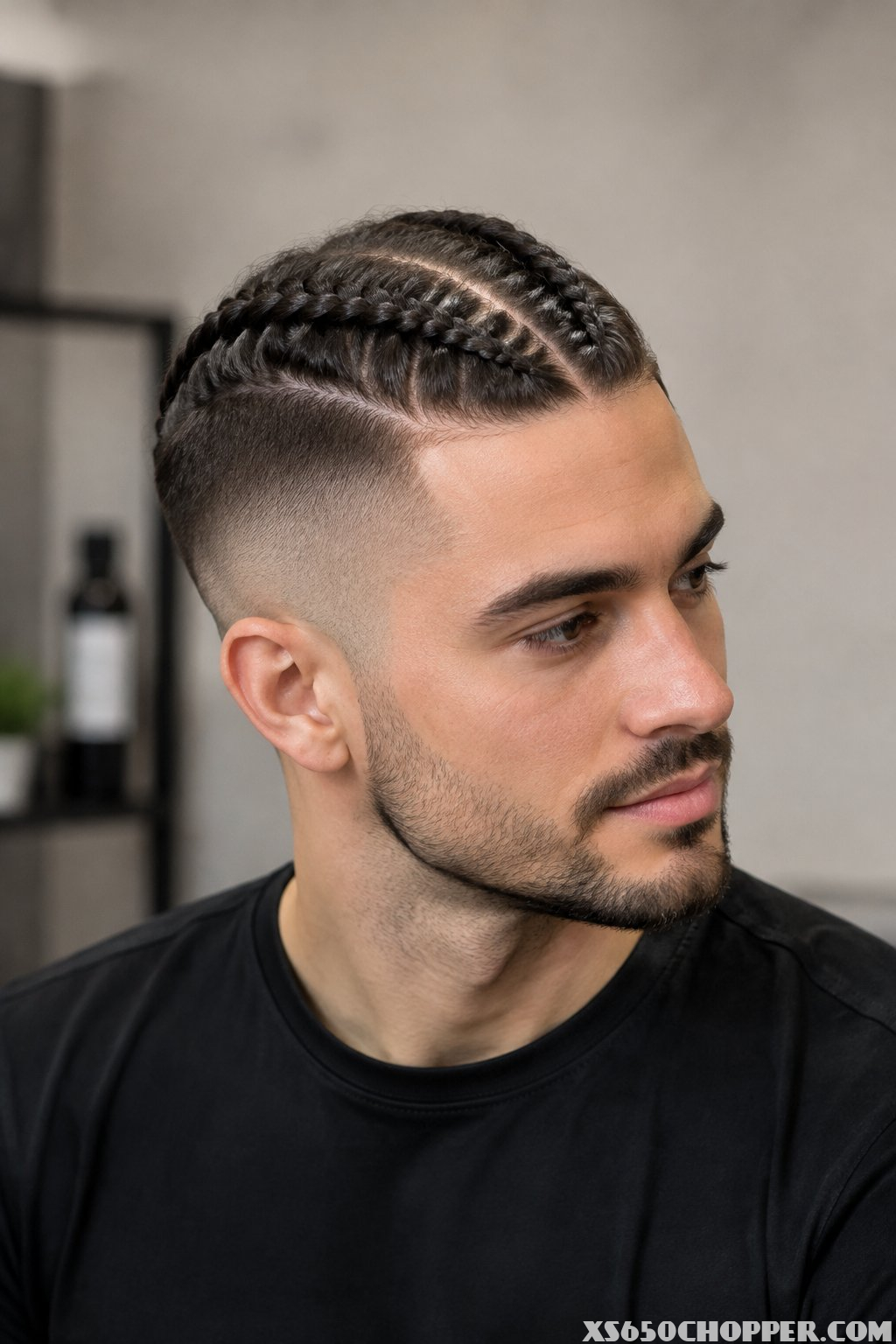 A man with braided hair and a faded haircut.