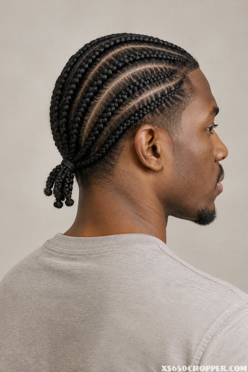 A man with braided hair, seen from behind.