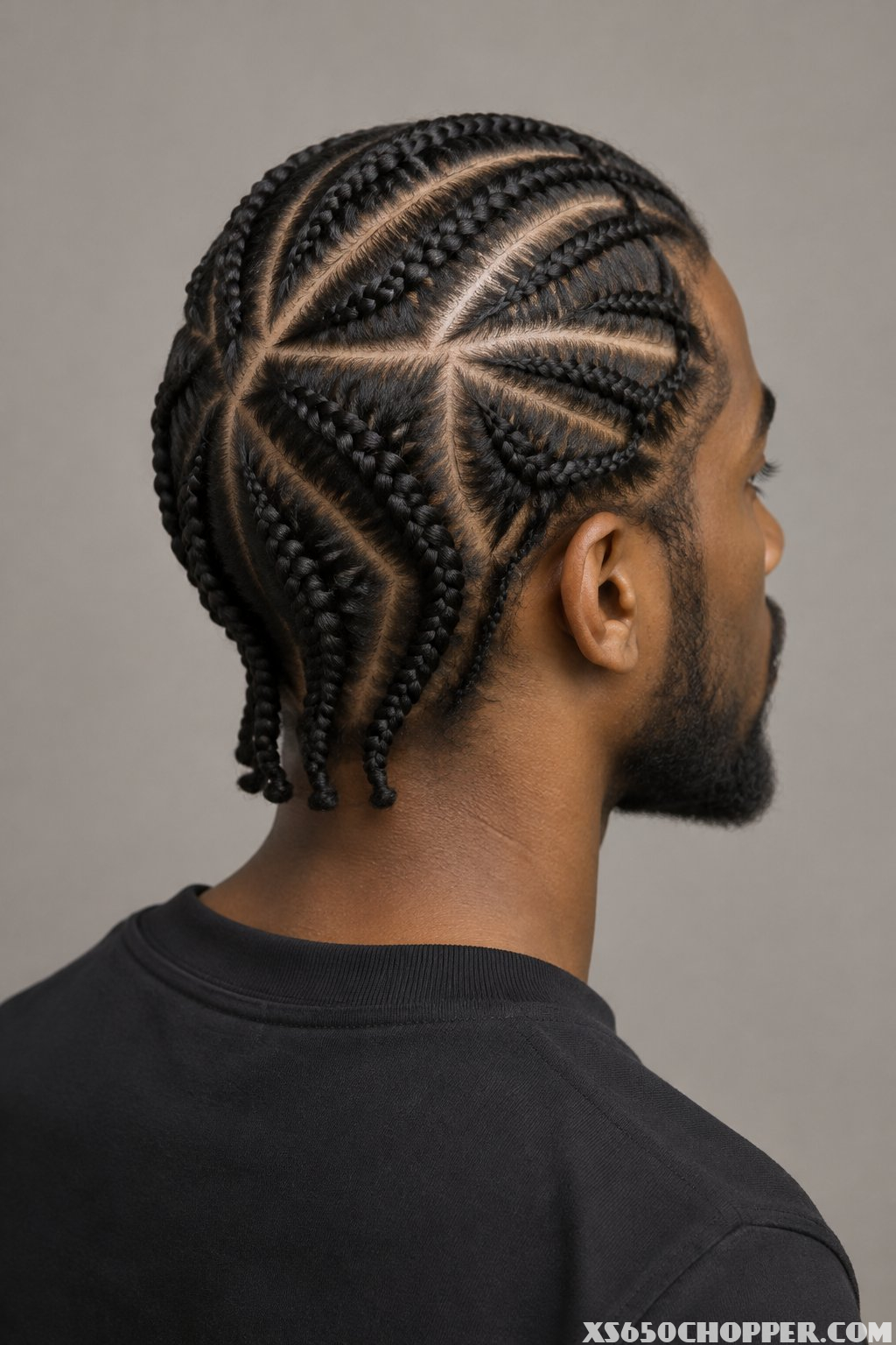 A man with braided hair photographed from the side.