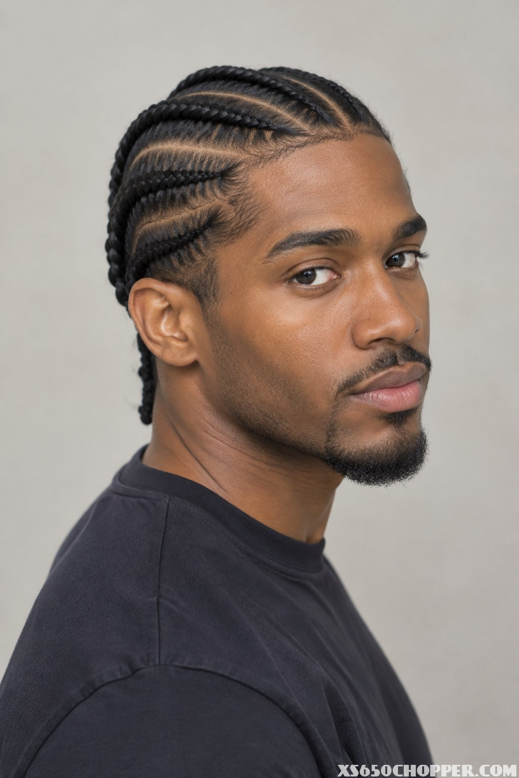 A man poses for a portrait against a plain background.