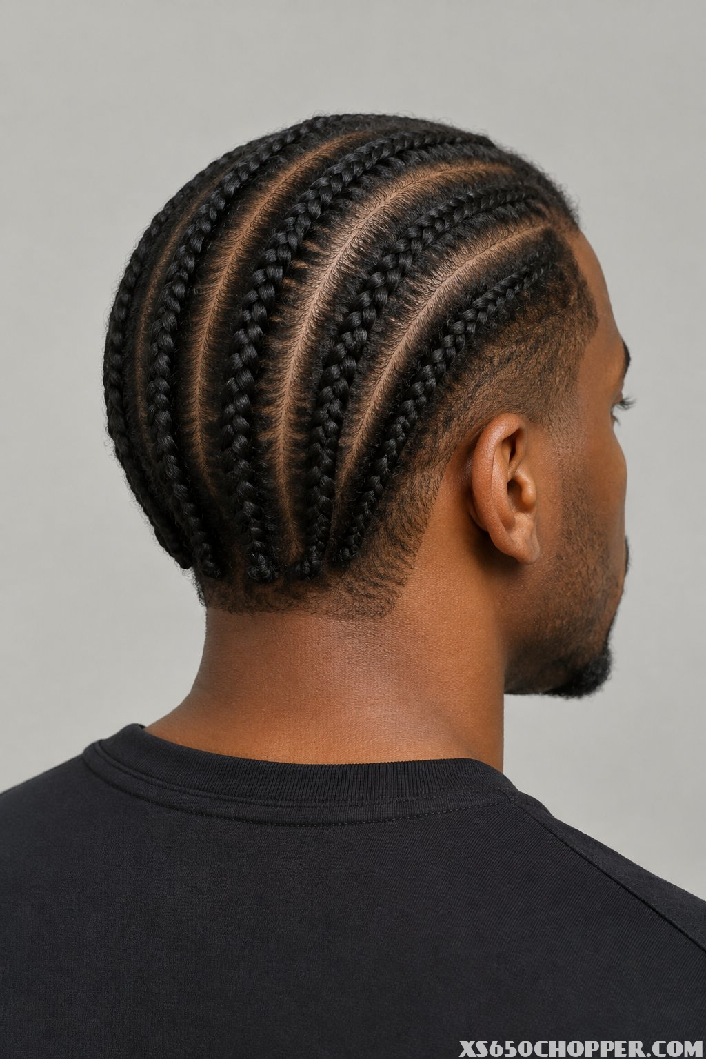A man with four neat braids running straight back across his head.