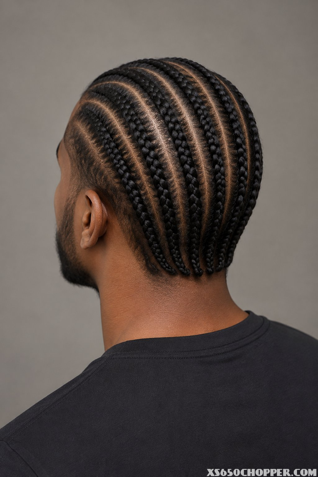 A man with braided hair viewed from behind.