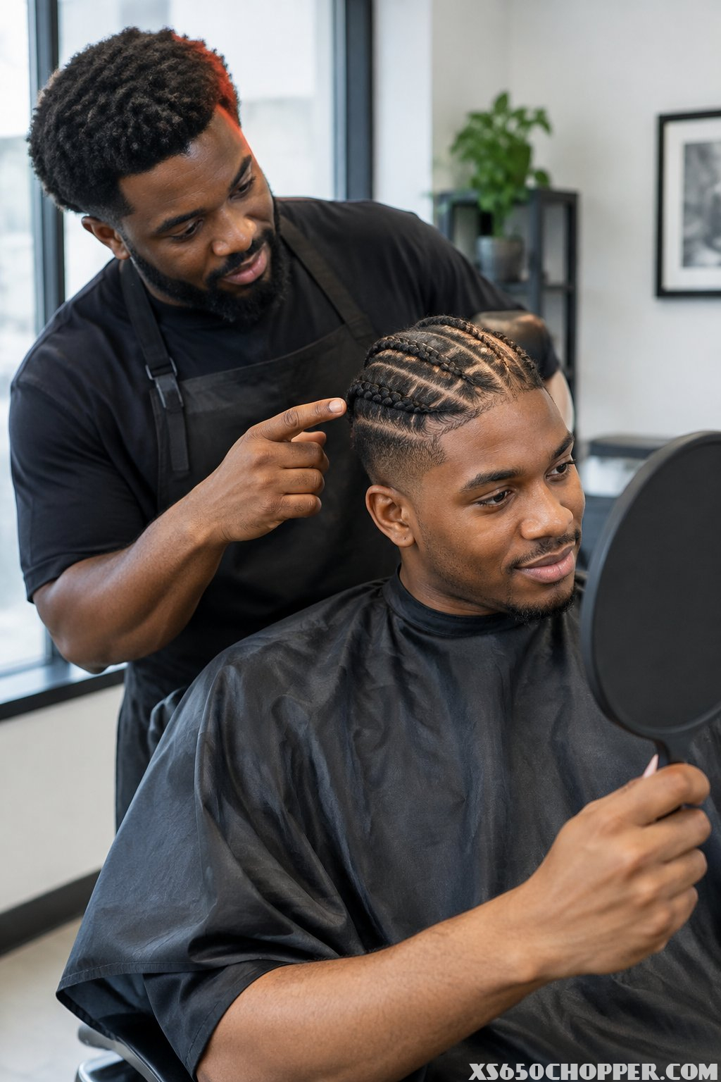 A man and barber sit together in a barbershop.