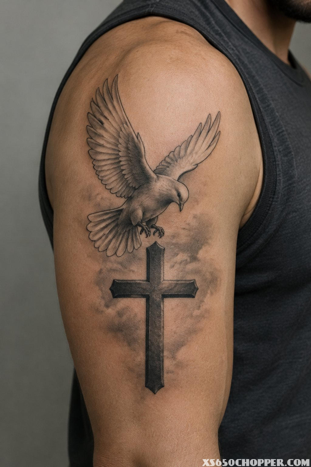A dove descends toward a cross tattoo on a man’s upper arm.