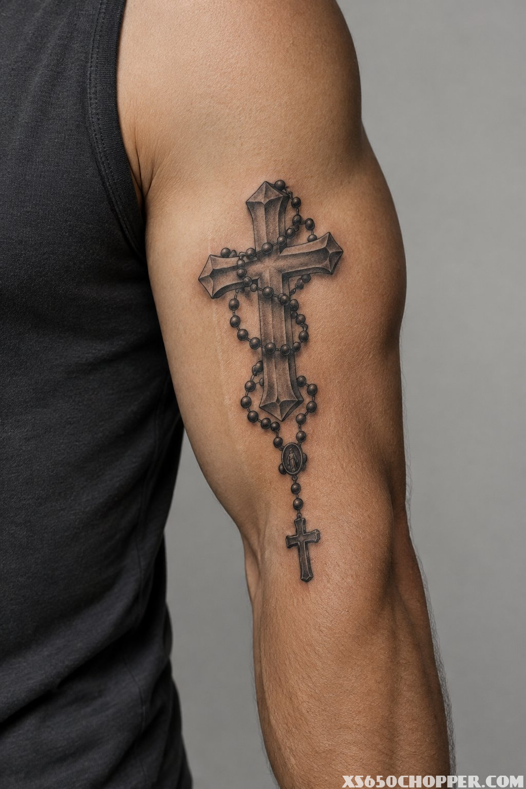 A man’s arm with a cross and rosary tattoo.